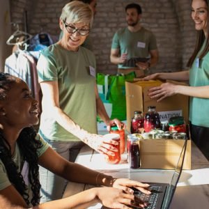 Group of volunteers with working in community charity donation center.